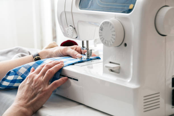 istock Hands of a woman using a sewing machine in tailor workshop. 1134322757