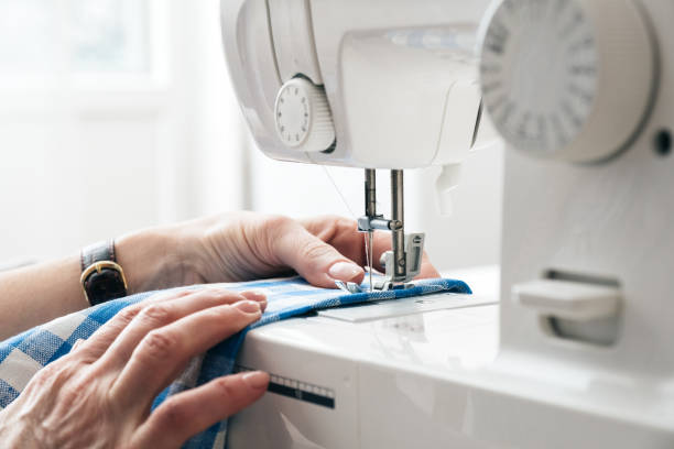 hands of a woman using a sewing machine in tailor workshop. - textile sewing women part of imagens e fotografias de stock