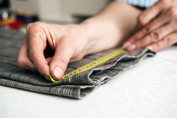 istock tailor using a measure tape to measure width of pants 1134322773