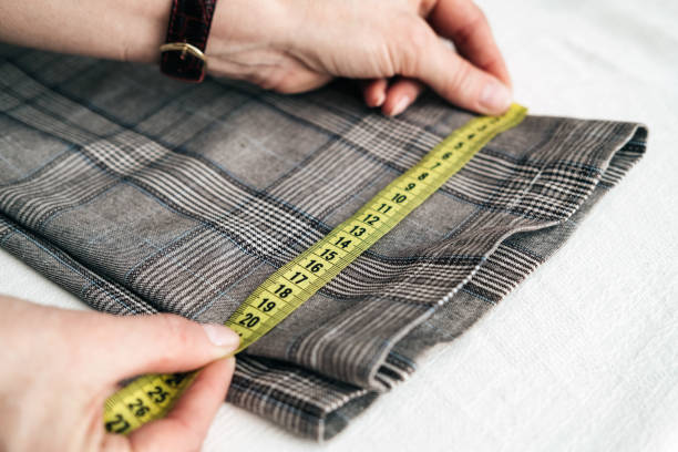 istock tailor using a measure tape to measure width of pants 1134322780