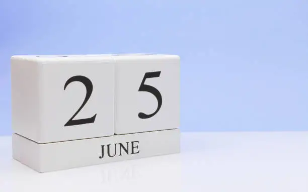 June 25st. Day 25 of month, daily calendar on white table with reflection, with light blue background. Summer time, empty space for text