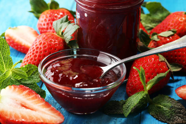 istock strawberry jam with fresh strawberries. marmalade on spoon and jar on blue 1134324920