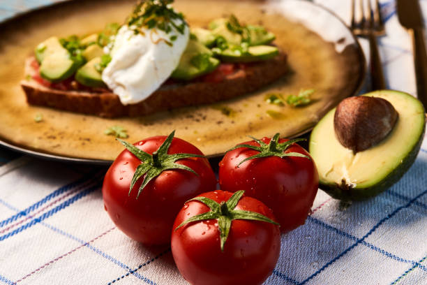 Fresh Avocado Toast and Poached Egg with Baked Tomatoes, close-up