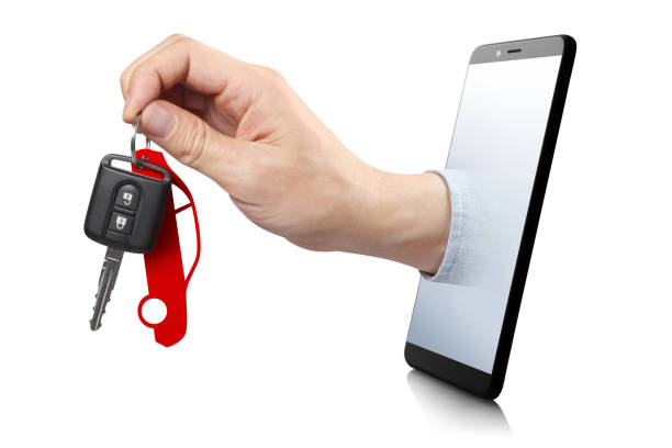 Hand with a car key Hand holding a car key, sticking out of the smartphone screen, isolated on white background carsharing photos stock pictures, royalty-free photos & images