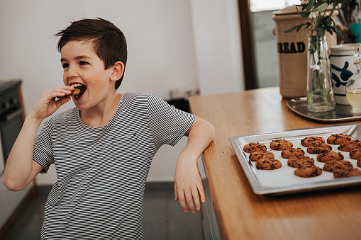 boy eating a cookie in the kitchen