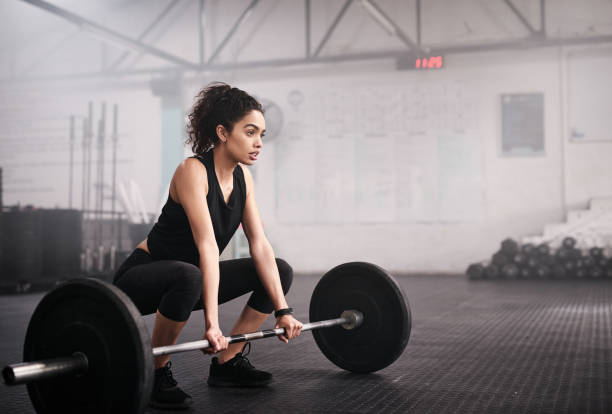 nossos corpos são capazes de qualquer coisa que nossas mentes acreditam - crouching exercising women barbell - fotografias e filmes do acervo