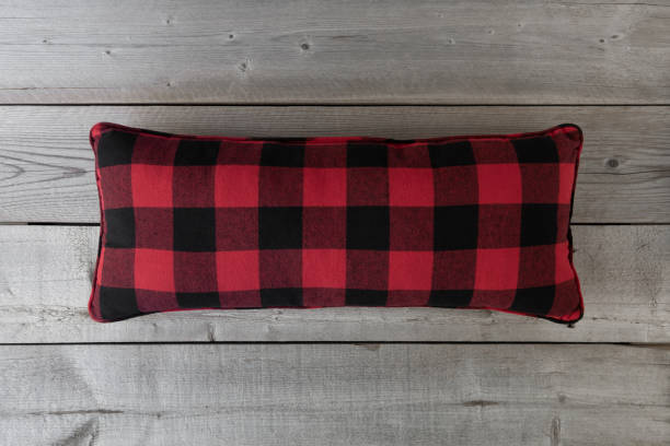 istock Red and black checkered lumbar cushion on grey wooden background. 1134334216