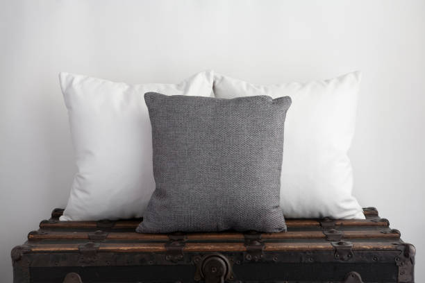 White square cushions with grey square cushion on old vintage suitcase.