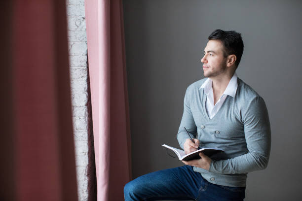 istock Male is holding a pencil and write something in note book. 1134334711