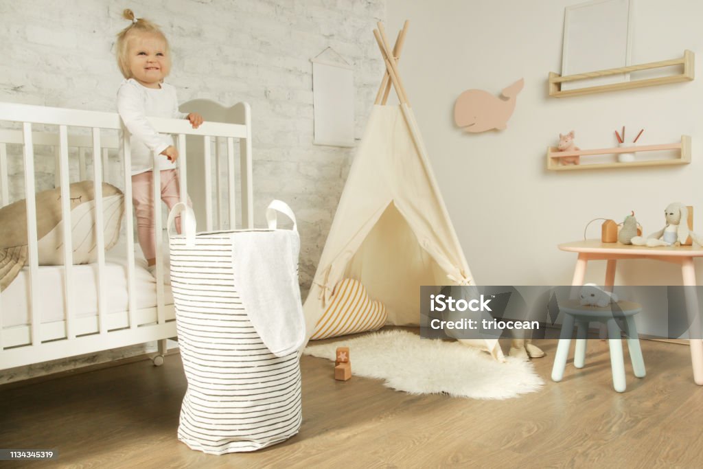 Porträt niedliche Baby Mädchen steht in der Krippe in ihrem Kinderzimmer - Lizenzfrei Kind Stock-Foto