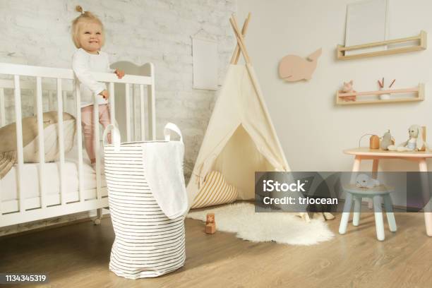 Porträt Niedliche Baby Mädchen Steht In Der Krippe In Ihrem Kinderzimmer Stockfoto und mehr Bilder von Kind