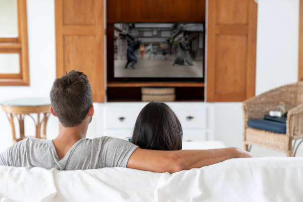 istock Loving couple watching television at home 1134350064