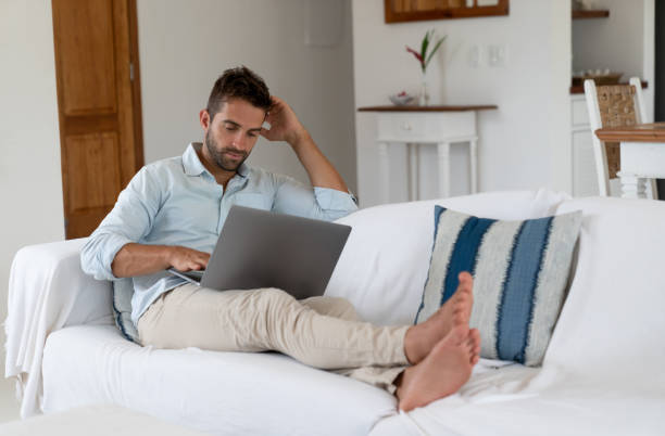 istock Man relaxing at home working online on a laptop computer 1134350074