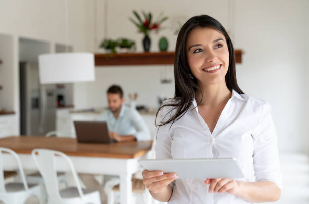istock Woman controlling her intelligent home system on a digital tablet 1134350078