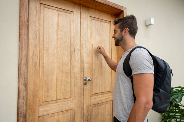 traveling man knocking on the door of a lodging house - lodging imagens e fotografias de stock