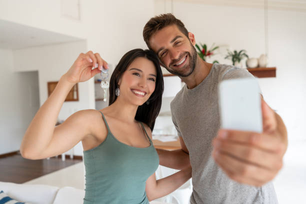 그들의 새로운 집의 열쇠를 들고 selfie을 복용 하는 행복 한 커플 - telephone home interior house residential structure 뉴스 사진 이미지