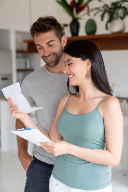 istock Couple at home looking happy reading a letter in the mail 1134350245