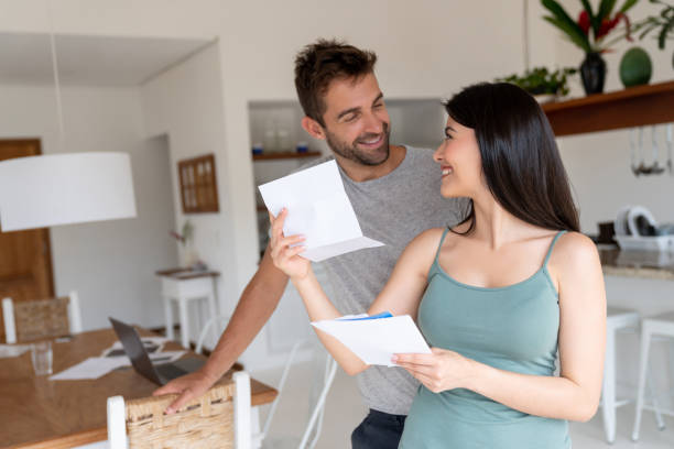 istock Couple at home looking happy checking their mail 1134350249