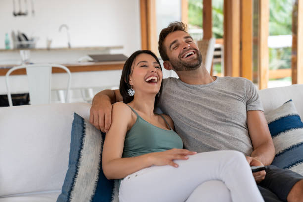 istock Happy couple watching television at home and laughing 1134350297