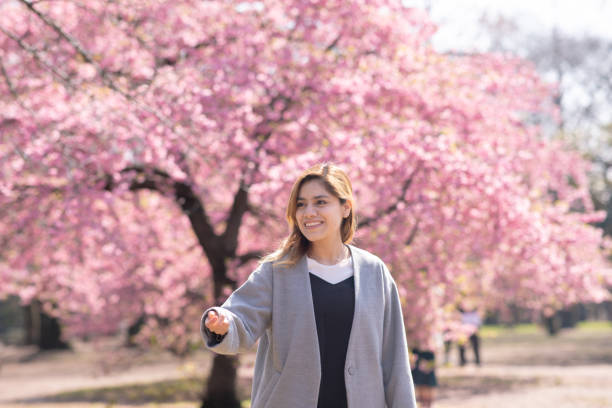 istock Young Hispanic woman playing flying disc under cherry trees 1134350436