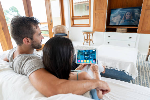 istock Couple watching tv and controlling their smart home on a tablet computer 1134352234