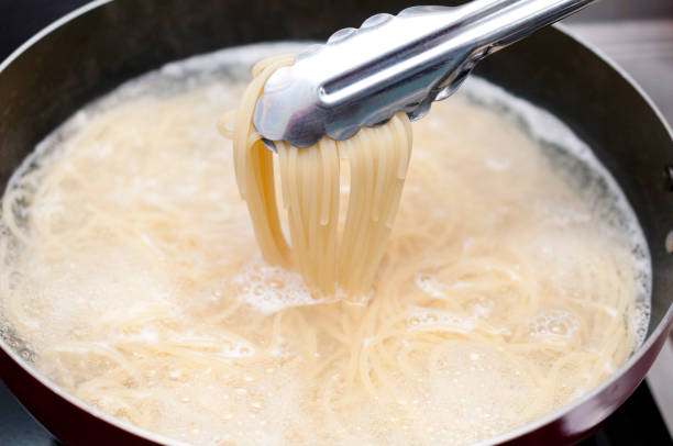 istock Pasta boiling in a pan with tongs 1134352310