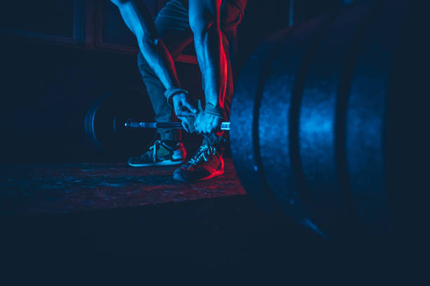 Man practicing weightlifting Handsome, muscular athlete is getting ready for dead lift workout. powerlifting stock pictures, royalty-free photos & images