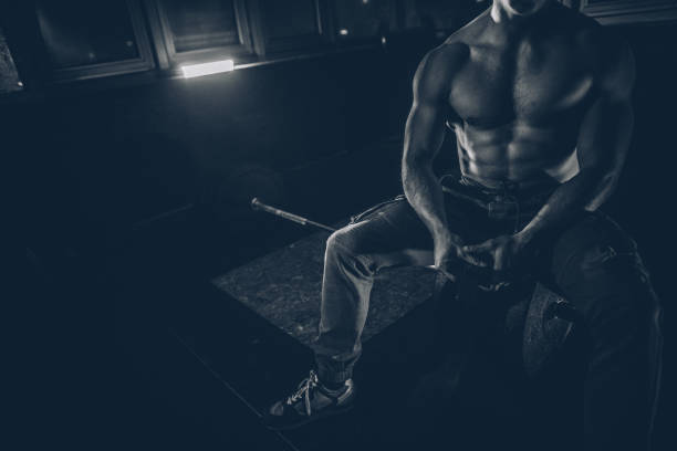 Handsome, muscular bodybuilder is sitting at the gym.