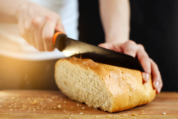 istock Fresh whole grain bread put on kitchen wood plate with a chef cuts masterfully it.  bread on table close-up.  traditional bakery and  healthy eating concept 1134362652