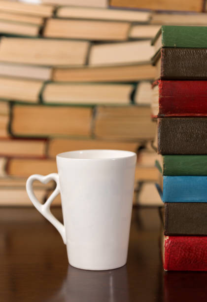 istock cup and many books on a wooden table 1134362954