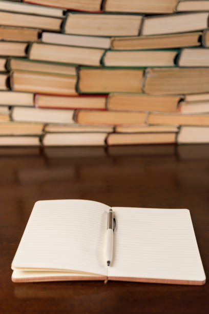 istock open notebook and books on wooden table 1134362975