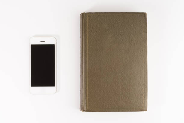 istock Smartphone versus old paper book, isolated on white background 1134364050
