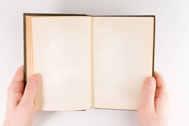 istock Overhead view of hands holding a blank book ready for text, isolated on white background 1134364060