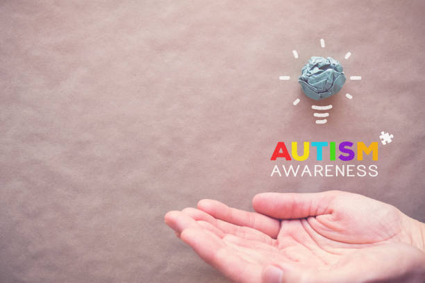istock Blue paper light bulb and puzzle on hands, world Autism awareness day 1134364922