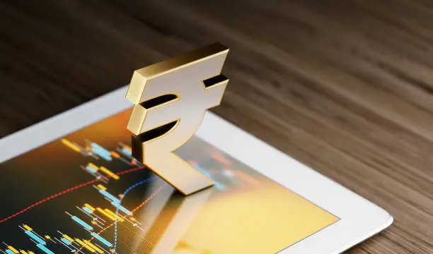 Rupee  symbol standing on a digital tablet. Selective focus. Horizontal composition with copy space.