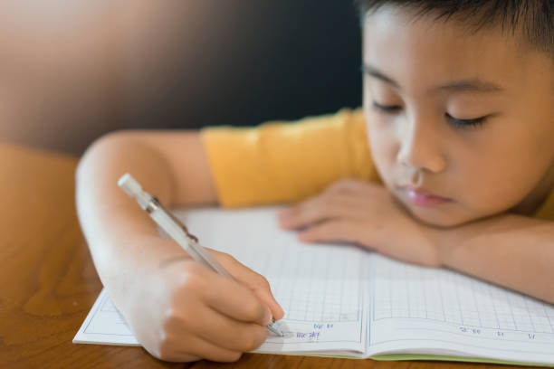 istock Little boy hand is writing homework at home.  Education concept 1134372801