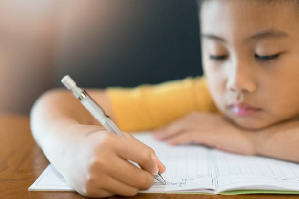 istock Little boy hand is writing homework at home.  Education concept 1134372816