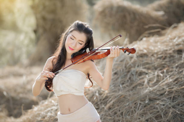 Charming girl violinist playing classical music. Isolated on white