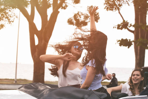 femme asiatique heureuse conduisant une voiture dans la ville. - motor vehicle outdoors crowd landscape photos et images de collection