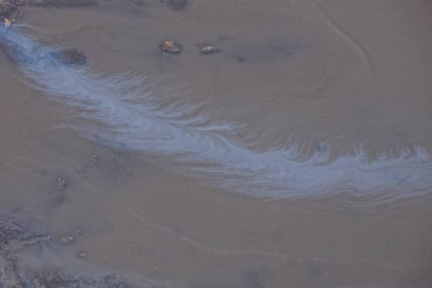 istock blue oil stain on dark brown water 1134388411
