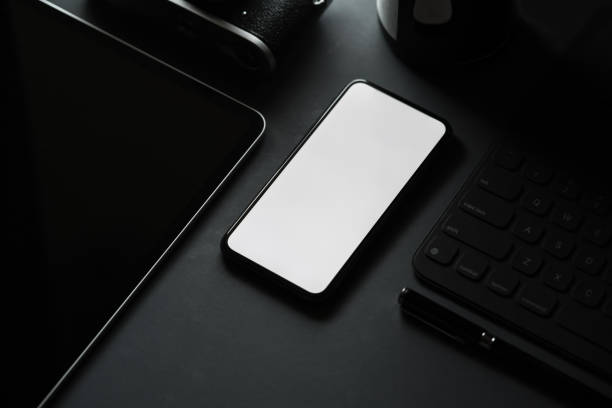 istock Office stationery with blank screen mobile smart phone on dark background. 1134390122