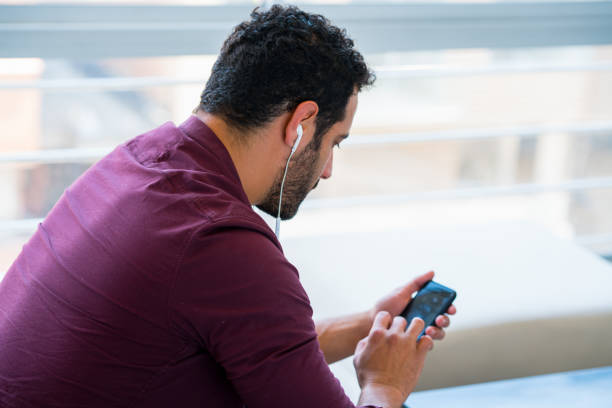 Latin man between 25-35 years old is listening to a podcast