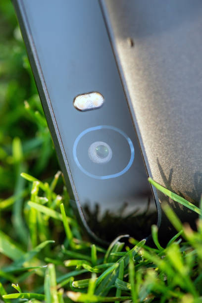 istock Smartphone camera with a flash close-up photo on green grass 1134397324