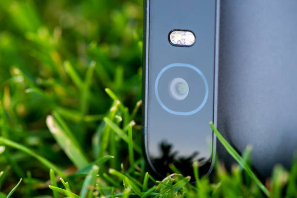 istock Smartphone camera with a flash close-up photo on green grass 1134397378