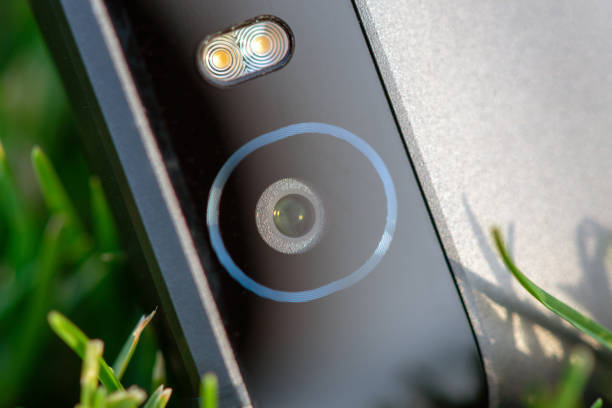 istock Smartphone camera with a flash close-up photo on green grass 1134397440