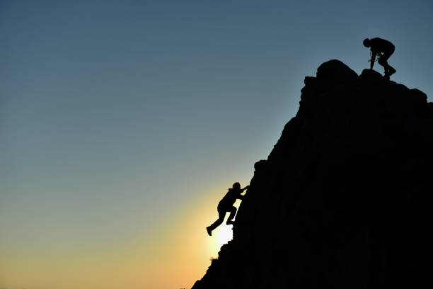 istock rock climbing striker and climber climbing without equipment 1134398626