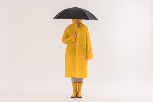 mujer adulta media con impermeable amarillo y botas de lluvia - isolated on white full length lifestyles yellow fotografías e imágenes de stock