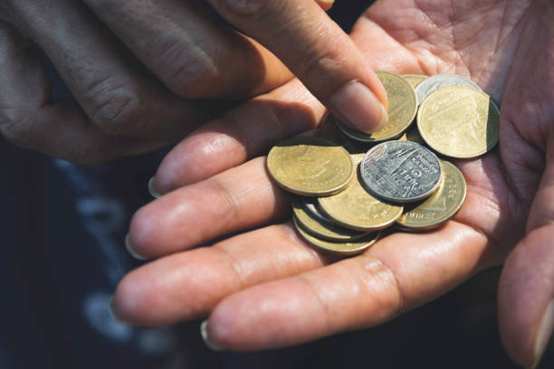istock Close up hand holding coins for saving concept on dark background. 1134404657