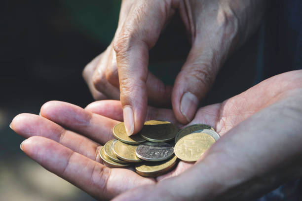 istock Close up hand holding coins for saving concept on dark background. 1134404677