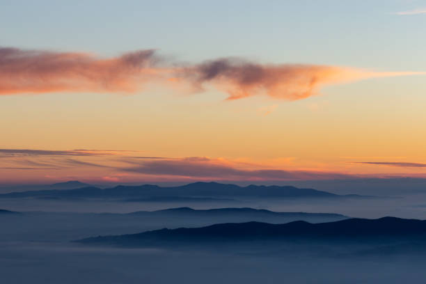 istock Beautifully colored sky at dusk, with mountains layers and mist between them 1134406053